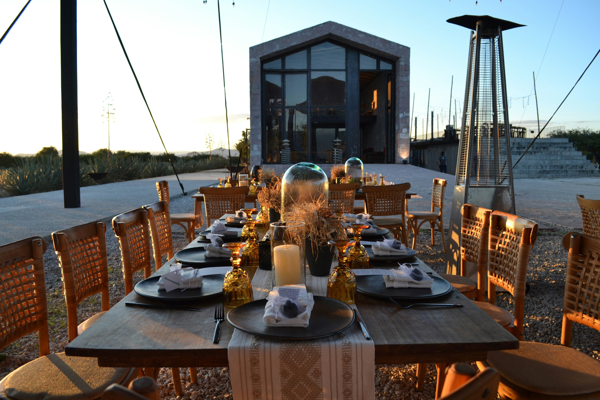 A long table set and waiting outside an architectural building in late afternoon